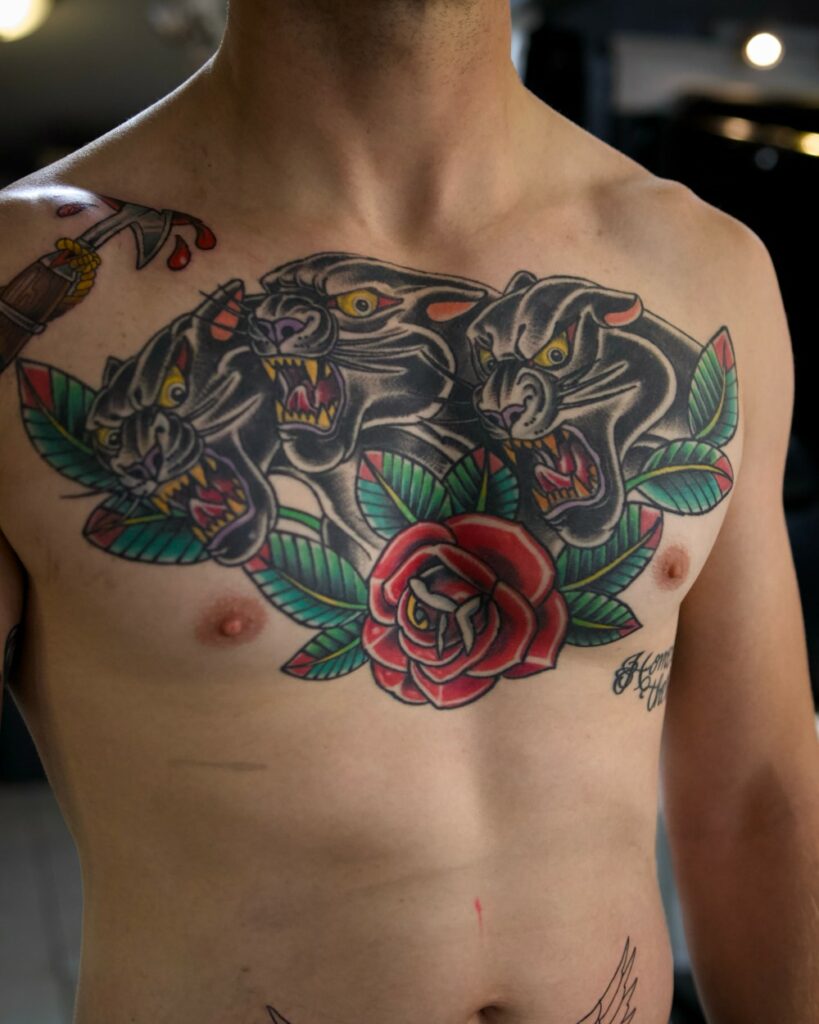 Traditional American panther tattoo with red rose on chest by Chris Cockrill, Remington Tattoo San Diego
